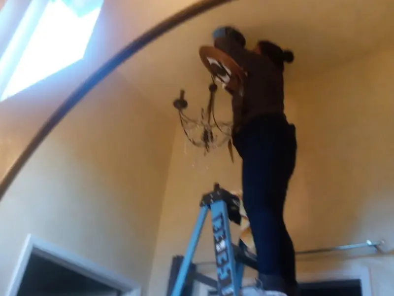 Electrician installing a chandelier in a Mulberry residence